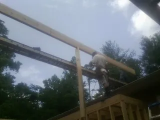 Carpenter setting a ridge beam over a new addition frame — Ice Dam Removal by Roofing Brothers in Copalis Crossing